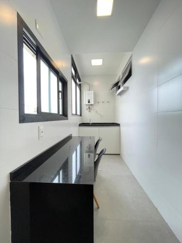 een keuken met een zwart aanrecht en een aantal ramen bij Ipanema - Rainha Elizabeth - 2 Quartos in Rio de Janeiro