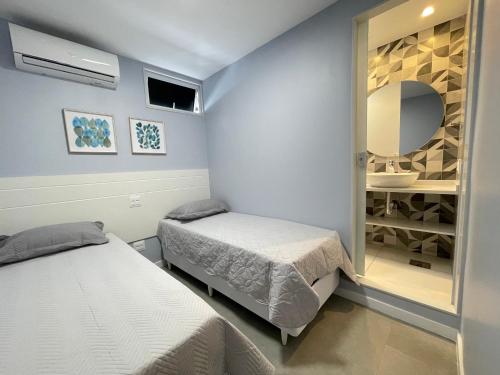 um quarto com 2 camas e um espelho em Ipanema - Rainha Elizabeth - 2 Quartos no Rio de Janeiro
