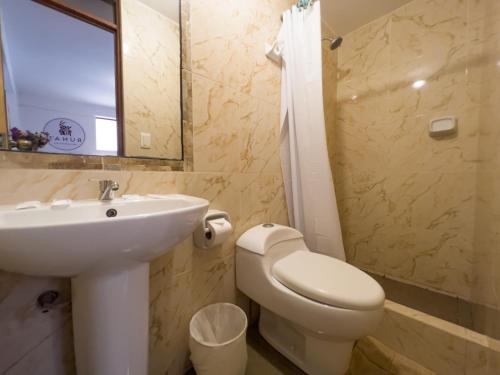 a bathroom with a sink and a toilet and a mirror at Runas Inn Machupicchu in Machu Picchu