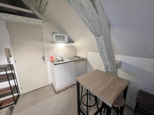 une petite cuisine avec un évier et une table dans l'établissement LE PACIFIC - Appartement spacieux centre ville, à Orléans