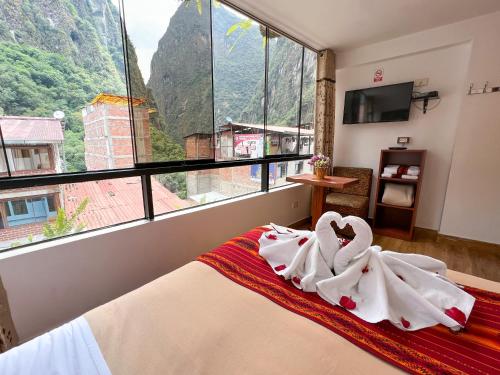 a bedroom with a bed with towels on it at Runas Inn Machupicchu in Machu Picchu