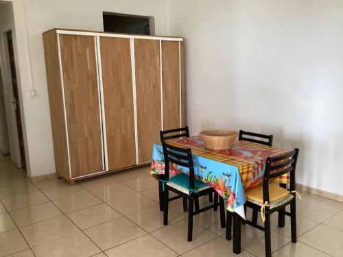 a dining room table with chairs and a cabinet at Appartement Montgeralde Fort-de-France in Fort-de-France