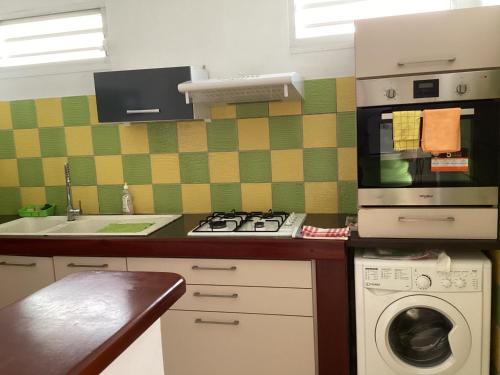 a kitchen with a stove and a washing machine at Appartement Montgeralde Fort-de-France in Fort-de-France