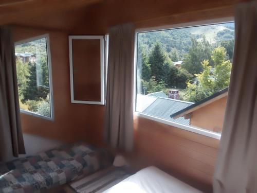 a bedroom with a large window with a view at Catedral view mínimo 4 noches in San Carlos de Bariloche