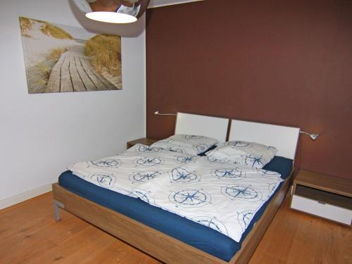 a bed in a bedroom with a picture on the wall at Holiday Home Sturmeck, Fehmarn-Orth in Orth