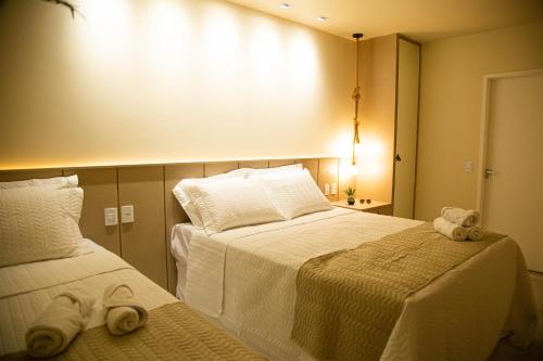 a hotel room with two beds with towels on them at Pousada Águas de Maragogi in Maragogi