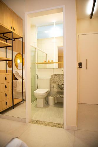 a bathroom with a toilet and a glass door at Pousada Águas de Maragogi in Maragogi