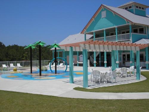 a house with a playground with tables and chairs at Cambridge Cove at Bermuda Bay by Kees Vacations in Kill Devil Hills