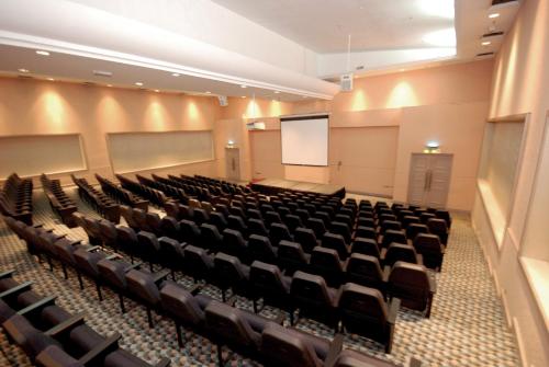 an empty lecture hall with chairs and a screen at Berjaya Waterfront Hotel, Johor Bahru in Johor Bahru