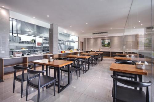 a restaurant with tables and chairs and a kitchen at Lanshan Moon Resort in Yangshuo