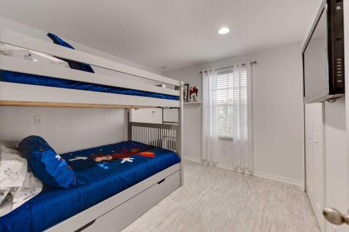 a bedroom with two bunk beds and a television at Welcome to Villa Azul, your home away from home! in Kissimmee