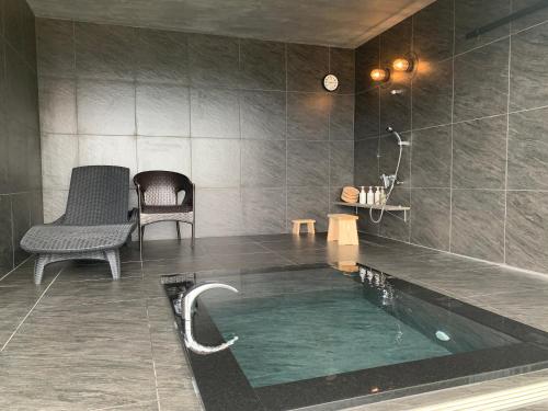 baño con piscina de agua en una habitación en お宿　弘法湯, en Kushimoto
