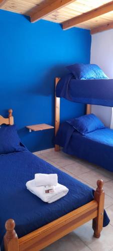 1 dormitorio con 2 literas y paredes azules en Cabaña Aike en El Calafate