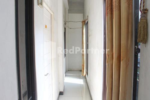 a hallway of a room with a door and a window at Snow White Residence near Grogol Mitra RedDoorz in Jakarta