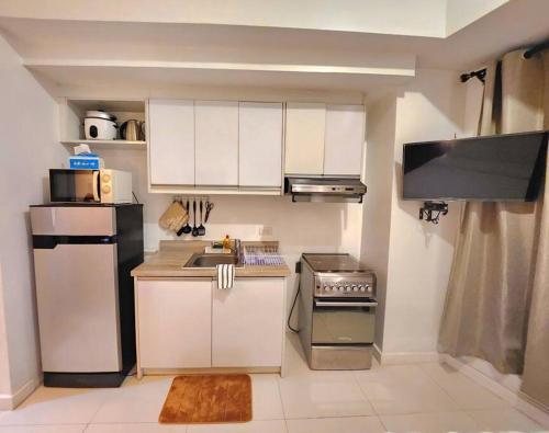 a small kitchen with a sink and a refrigerator at Modern Hotel-type Studio near Greenbelt Netflix 100mbps in Manila