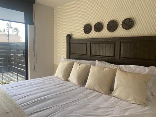 1 cama con almohadas blancas en un dormitorio con ventana en ACOGEDOR DEPARTAMENTO en zona de Santa Fé, en Ciudad de México