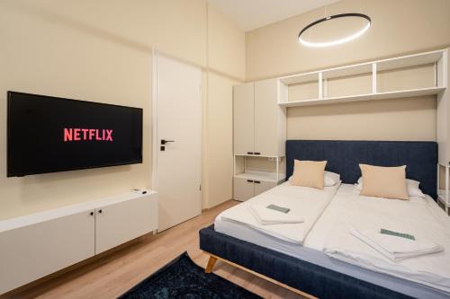 a bedroom with a bed with a tv on the wall at N36- Boutique Apartments, Best Location, By BQA in Budapest