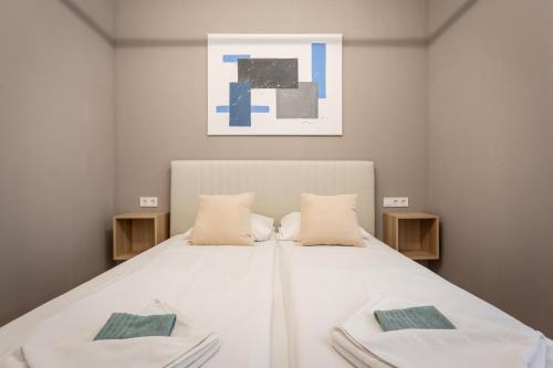 una camera con un letto bianco con due cuscini di N36- Boutique Apartments, Best Location, By BQA a Budapest