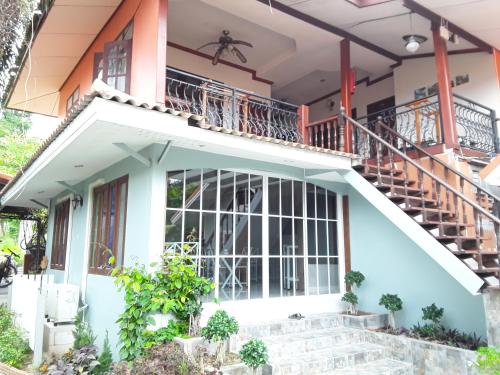 a house with a balcony and stairs at Barbados Terrace in Ko Samed
