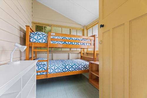 a bedroom with two bunk beds in a house at The Seamist Cottage in Narooma