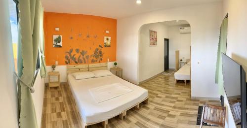 sypialnia z 2 łóżkami i pomarańczową ścianą w obiekcie Như Mây Homestay w Duong Dong