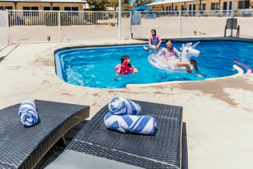 un grupo de niños jugando en una piscina en Outback Motel Mt Isa, en Mount Isa