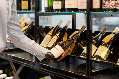 a person is holding a bunch of wine bottles at Crowne Plaza Surfers Paradise by IHG in Gold Coast