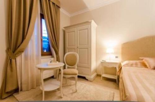 a bedroom with a bed and a table and a tub at Residenza Marchesi Pontenani in Florence