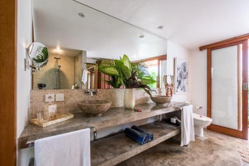 a bathroom with two sinks and a large mirror at Baby Melon Villas in Seminyak