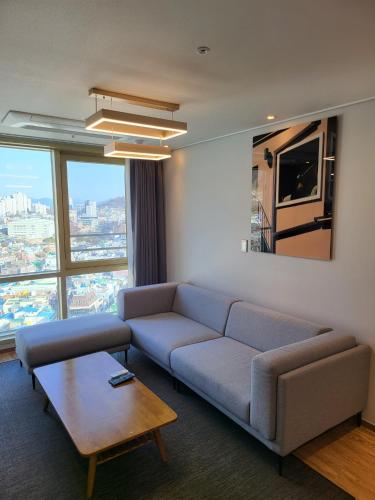 ヨス市にあるHotel Kenny Yeosuのソファとテーブルのあるリビングルーム