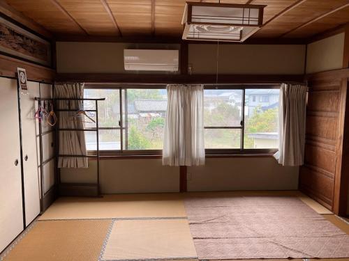 an empty room with a large window and a door at Guest house my home 