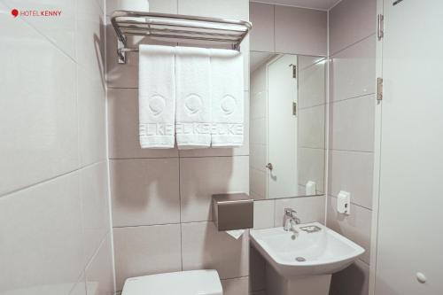 een badkamer met een wastafel, een toilet en een spiegel bij Hotel Kenny Yeosu in Yeosu