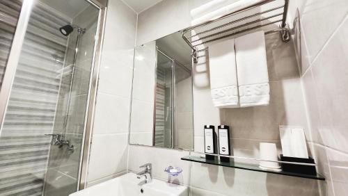 a white bathroom with a sink and a mirror at Haeundae Blue Story Hotel in Busan