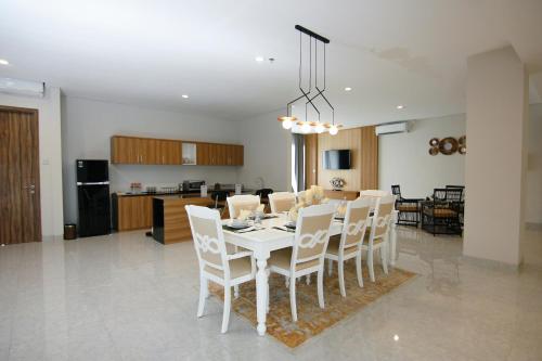 a dining room and kitchen with a white table and chairs at Raja Hotel Kuta Mandalika Resort & Convention in Kuta Lombok