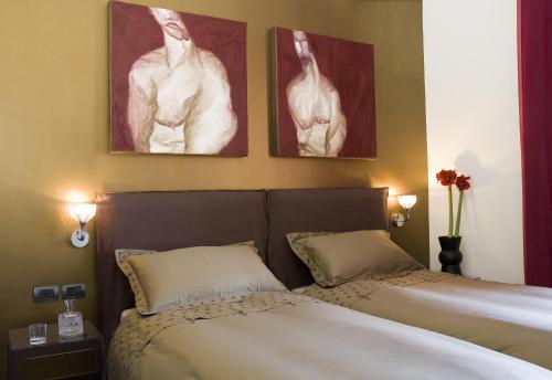 2 camas en un dormitorio con pinturas en la pared en Eh13 Luxury Accommodation, en Catania