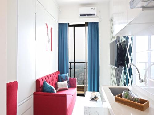 a living room with a red couch and blue curtains at MORITZ INN BSD TANGERANG in Tangerang