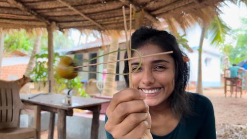 a woman is holding up a piece of wood at HostelExp, Gokarna - A Slow-Paced Backpackers Community in Gokarna