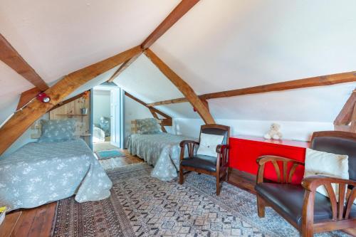 a attic bedroom with two beds and a chair at Villa de 5 chambres avec piscine privee jardin clos et wifi a Bourre a 4 km de la plage in Bourré
