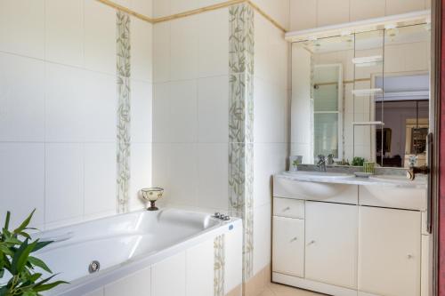 une salle de bain avec une baignoire et un lavabo dans l'établissement Villa élégante à Bourré + piscine, à Bourré