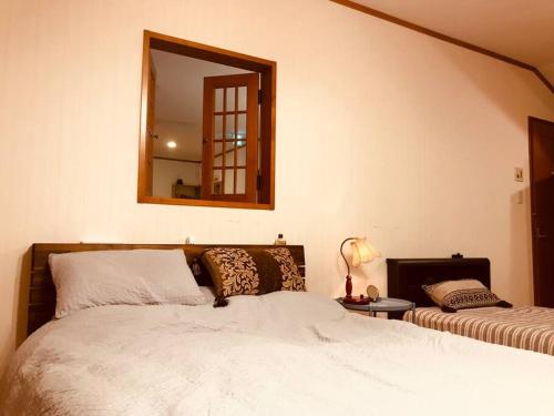 a bedroom with a large bed and a mirror at 森の香 in Matsue
