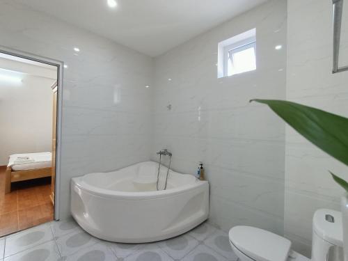 頭頓的住宿－Ann Homestay Vũng Tàu，白色的浴室设有浴缸和卫生间。