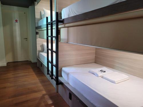 a bunk bed with a book on it in a room at Wink at Upper Cross Street in Singapore