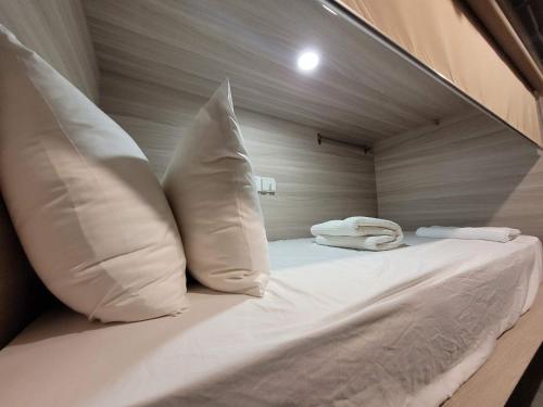 1 cama con 2 almohadas en una habitación en Wink at Upper Cross Street, en Singapur