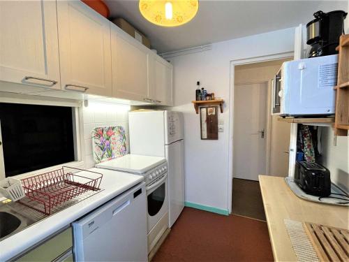 La cuisine est équipée de placards blancs et d'un four avec plaques de cuisson blanches. dans l'établissement Appartement 3 pièces, 6 couchages à La Salle-les-Alpes, proche pistes, balcon et terrasse - FR-1-330F-41, à Serre Chevalier