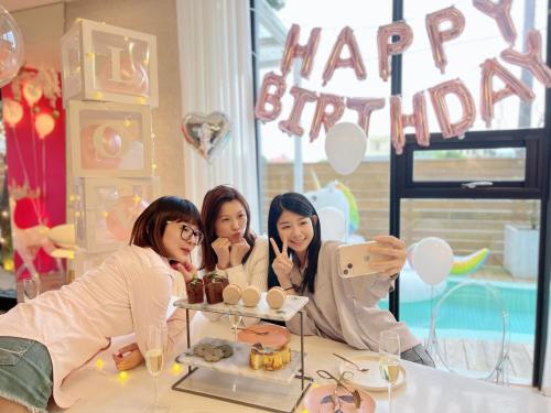 three girls sitting at a table with a happy birthday sign at Villa Le Ballon Bleu in Wujie