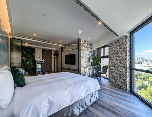 a bedroom with a large bed and a large window at K Hotel - Yizhong in Taichung