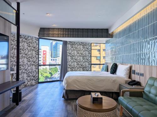 une chambre d'hôtel avec un lit et un canapé dans l'établissement K Hotel - Yizhong, à Taichung