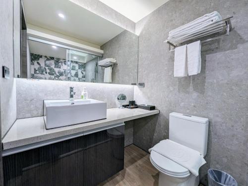 a bathroom with a white sink and a toilet at K Hotel - Yizhong in Taichung