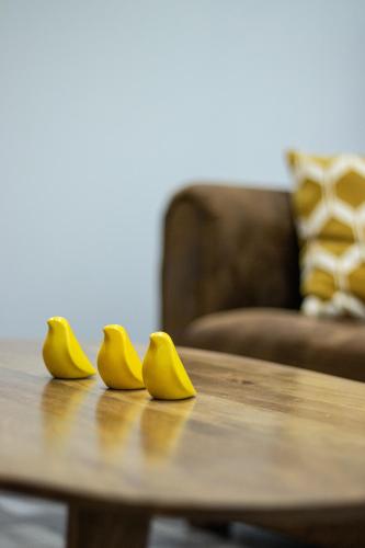 two yellow rubber shoes sitting on a wooden table at Les Granges de Jules in Lafitte-Vigordanne
