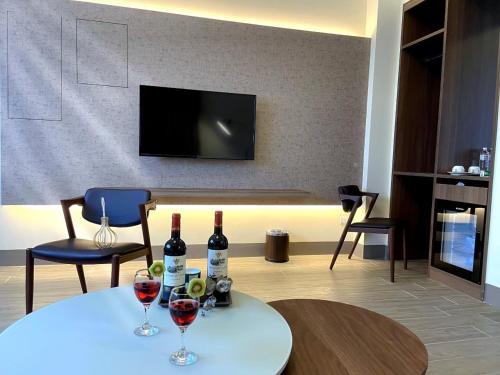 ein Wohnzimmer mit 2 Gläsern Wein auf dem Tisch in der Unterkunft Hoya Spa Hotel in Ruisui